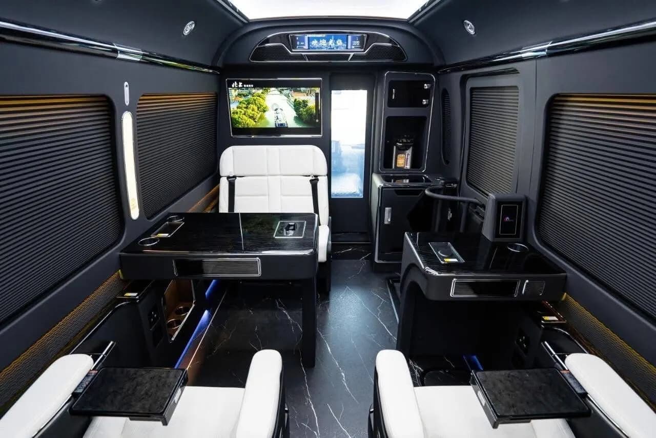 Twin-row Sprinter cabin with side tables and individual seat consoles
